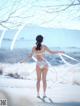 A woman in a white lingerie standing in the snow.