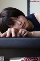 A woman laying on top of a table with her hand on her chin.