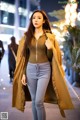 A woman walking down a city street at night.