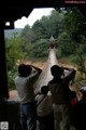 A group of people standing on a wooden bridge.