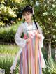 A woman in a colorful dress standing in a garden.