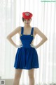 A woman in a blue dress and a red hat.