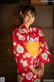 A woman in a red kimono posing for a picture.