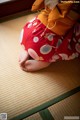 A woman in a kimono sitting on a tatami mat.