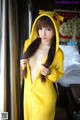 A woman in a yellow pikachu costume posing for a picture.