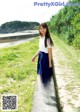 A young woman in a white shirt and blue skirt posing for a picture.