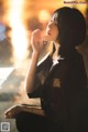 A woman sitting on the ground smoking a cigarette.