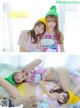 A couple of girls laying on top of a bed.